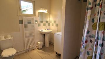 Een badkamer met toilet, wastafel en douchegordijn.