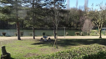 A park with a lake, trees, and a picnic table.