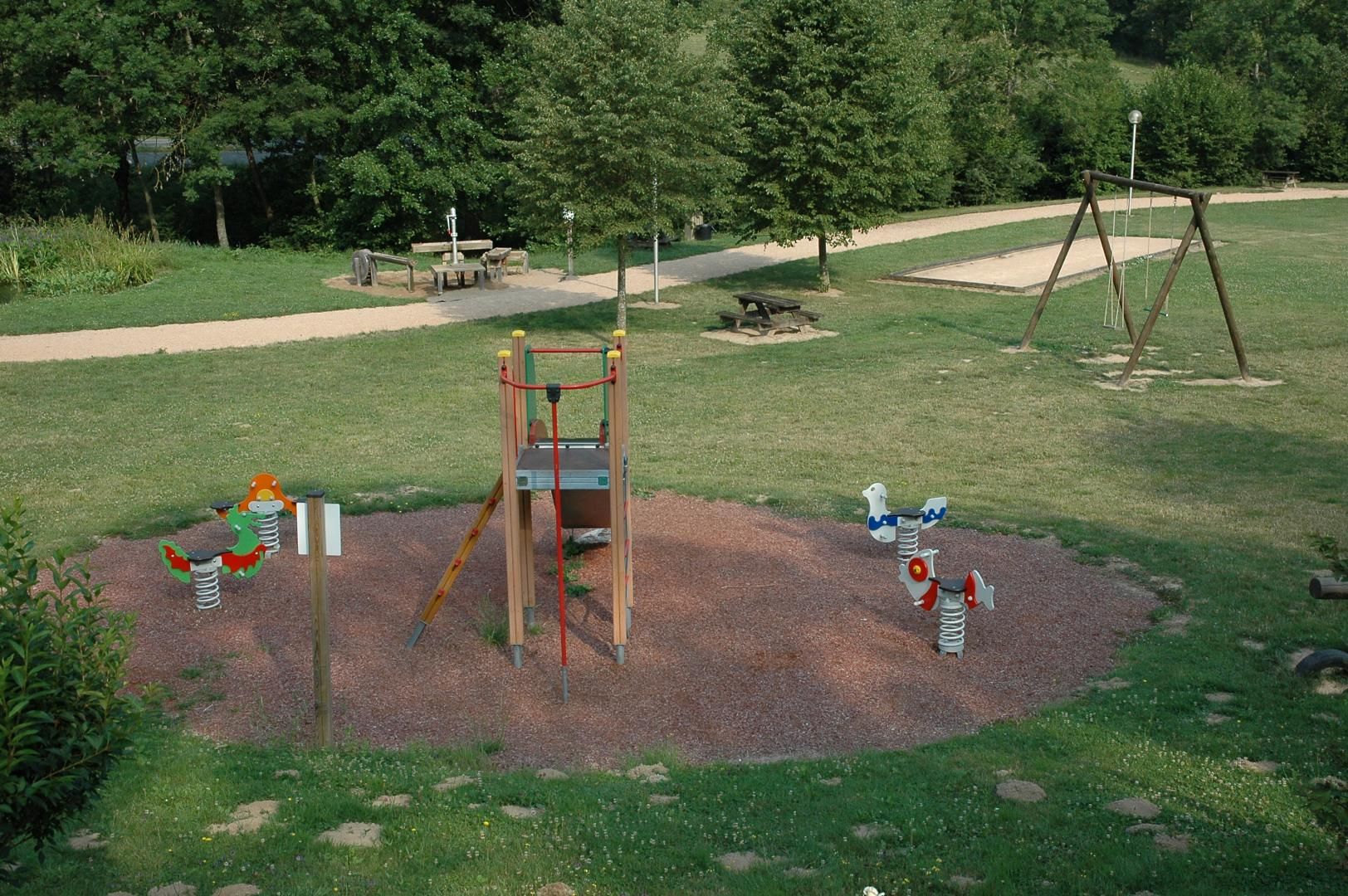 Ein Spielplatz mit einer Holzwentil, einer Kletterkonstruktion und einem Sandkasten.