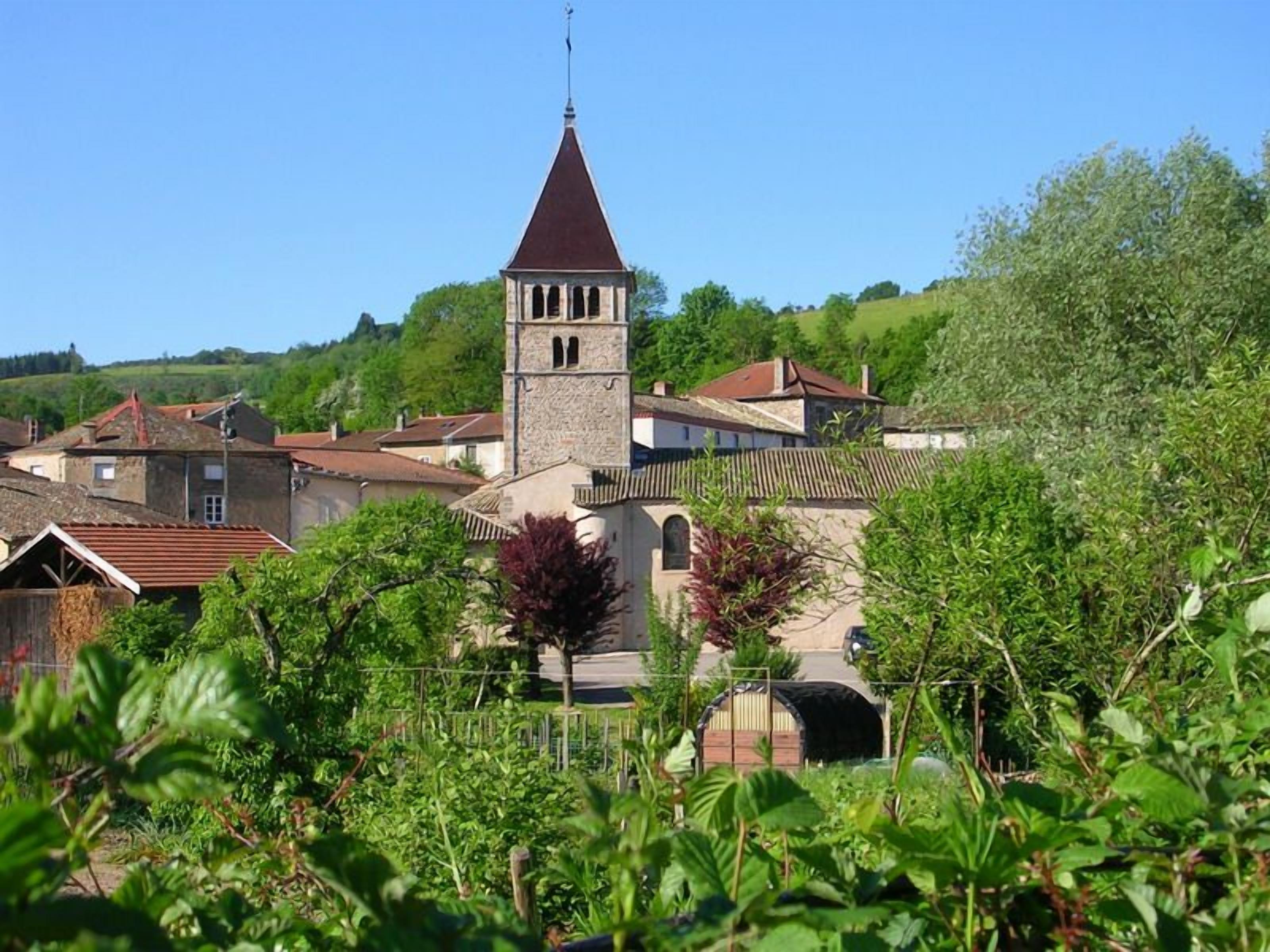 Eine historische Stadt mit einem markanten Kirchturm, umgeben von Wohnhäusern und üppigem Grün.