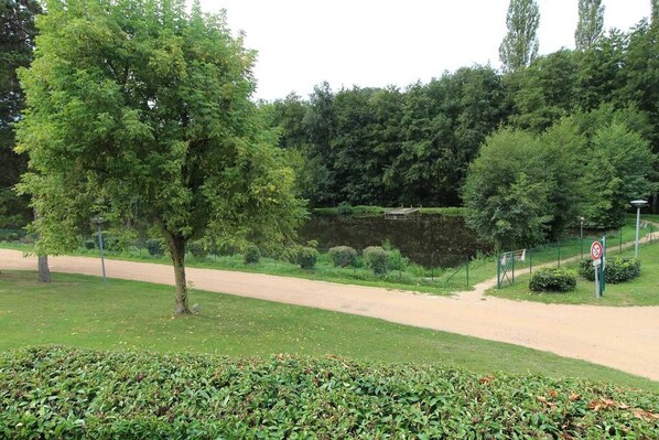 Een park met een onverhard pad, een vijver en een verboden toegangsbord.