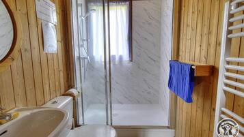 A bathroom with a shower, toilet, and bathtub.