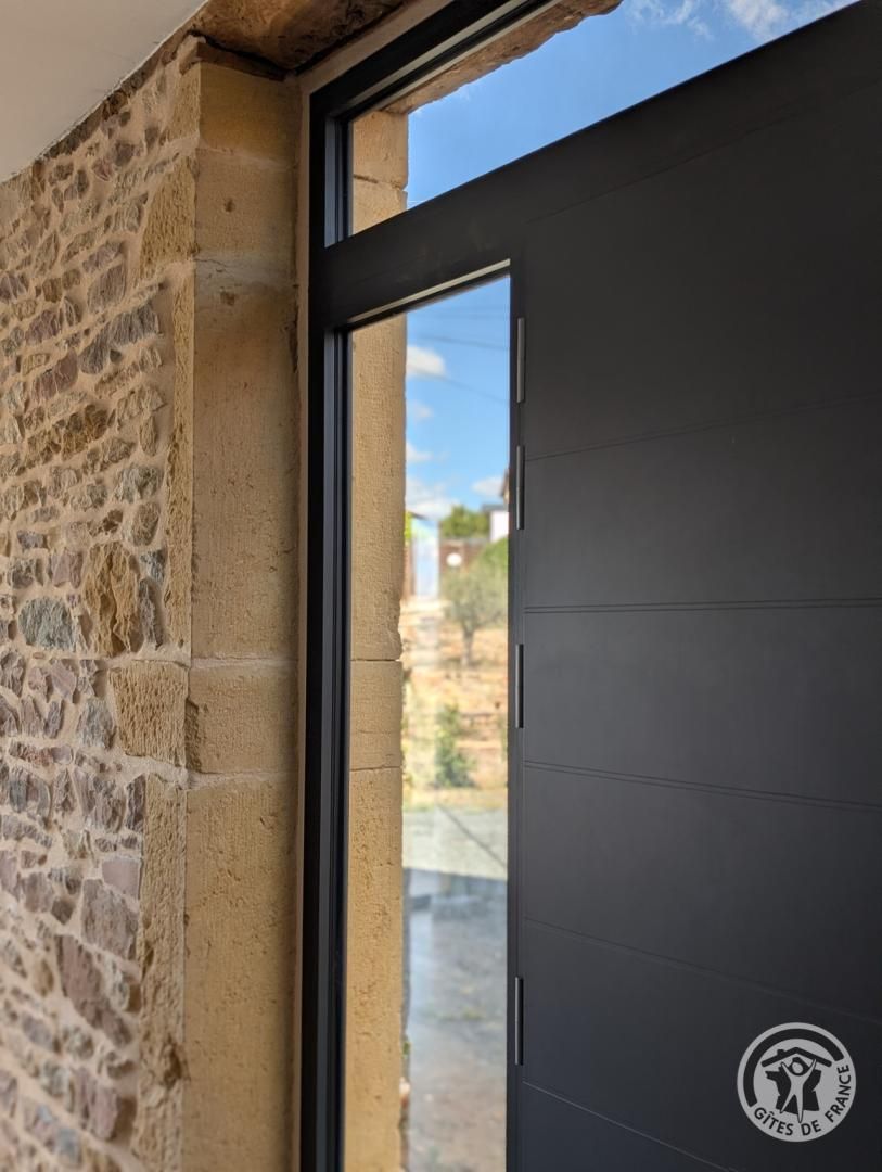 Pareda de pedra ao lado de uma porta moderna com janela.