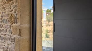 Pareda de pedra ao lado de uma porta moderna com janela.