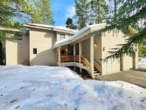 A two-story house with a covered porch and a wooden staircase leading to the second floor. - Family Basecamp - Close to Lake Tahoe, Beaches, Trails & Ski Resorts (Tahoe City)