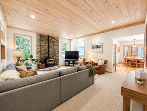 Ein gemütliches Wohnzimmer mit Kamin, einer großen Couch und einem Fernseher.