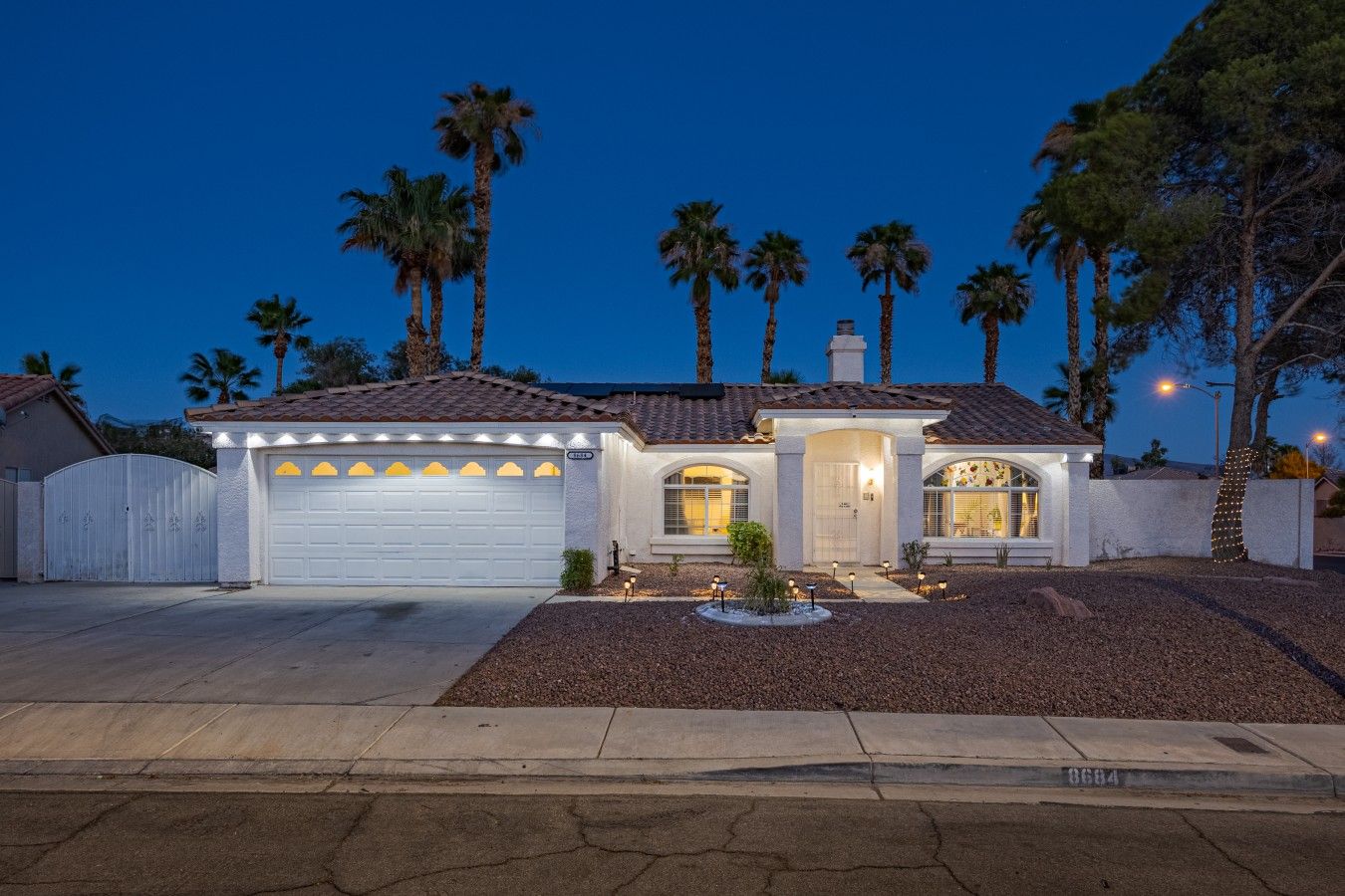 A residential house with a garage, a driveway, and a well-maintained lawn.