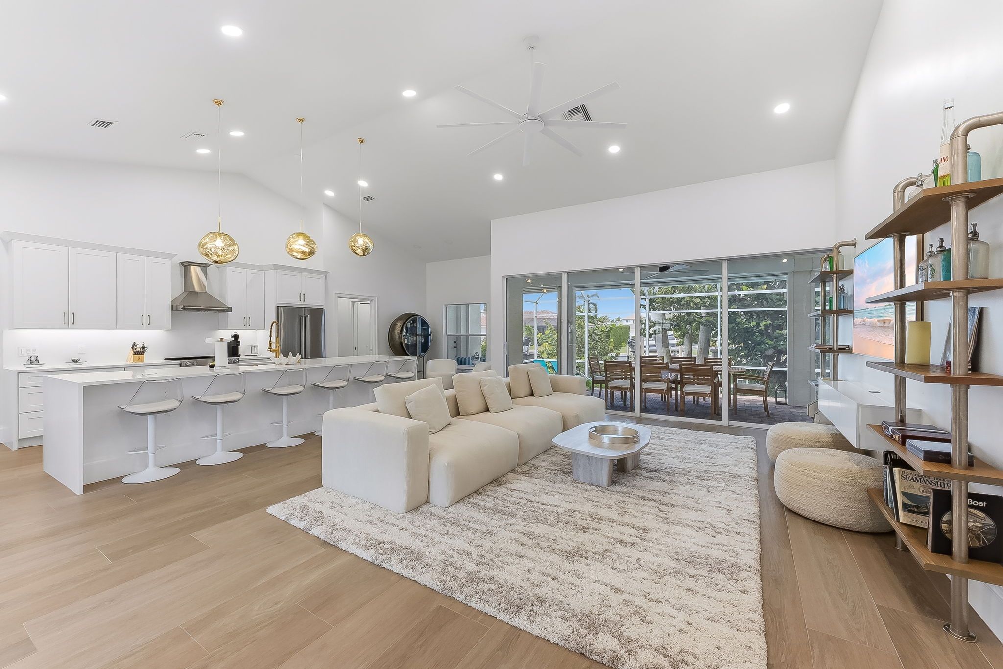 A modern kitchen with white cabinetry, a central island, and pendant lighting.