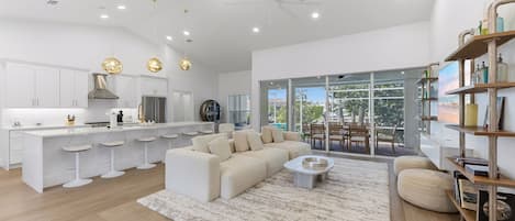 A modern kitchen with white cabinetry, a central island, and pendant lighting.
