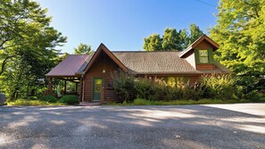A wooden cabin with a sloped roof, a front porch, and a gravel driveway. - Sunset Ridge View by Avantstay Hot Tub + Game Room Mountain Views Near Dollywood (Sevierville)