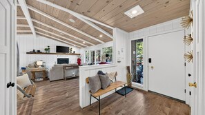 Een ruime woonkamer met een open haard, een eettafel en een bank.