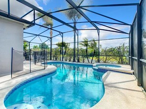 A swimming pool with a glass ceiling, surrounded by palm trees and a clear sky. - Elegant 5BR Home w/ Pool Spa Near Disney (Davenport)