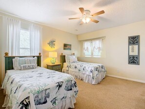 A bedroom with two beds, a ceiling fan, and a window with curtains. - Elegant 5BR Home w/ Pool Spa Near Disney (Davenport)