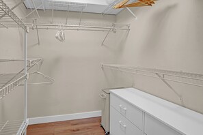 A walk-in closet with metal shelving units, a white dresser, and a radiator. - Heated Pool, Luxury Furnishings, Equipped Kitchen, Close to Beach and Downtown (Stuart)