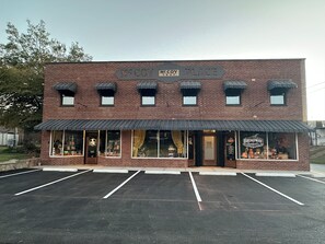 A brick building with a storefront labeled 'Broadway Beauty & Co.' and a parking lot in front. - Lily's Oasis located in recently renovated historic McCoy Place Lofts. (Cave City)