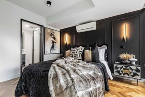 A modern bedroom with a large bed, dark walls, and a geometric-patterned nightstand. - VAQUAY The Sable Gallery In Melbourne CBD (Melbourne)