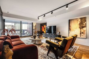 A modern living room with a large window, a flat-screen TV, and a large abstract painting. - VAQUAY The Sable Gallery In Melbourne CBD (Melbourne)