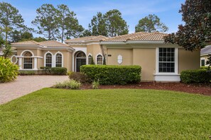 A residential building with a tiled roof, arched windows, and a well-maintained lawn. - Elegant Country Club House with Pool View of the 14th Hole (Orange Park)