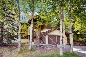 A two-story house with a wooden staircase leading to a deck. - East Vail home with private hot tub, A/C and Vail Village ski lockers (Vail)
