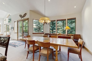 A dining area with a large wooden table, chairs, and a chandelier. - Spacious East Vail retreat with 4 bedrooms, private hot tub, and amazing location (Vail)