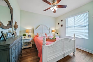 A bedroom with a white bed, wooden dresser, and a ceiling fan. - Waterfront Paradise, Private Dock, 4BR, 2 bath,  Private Pool & Mins to Downtown (Punta Gorda)