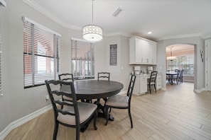 A dining area with a round table, dark wooden chairs, and a pendant light. - Waterfront Paradise, Private Dock, 4BR, 2 bath,  Private Pool & Mins to Downtown (Punta Gorda)