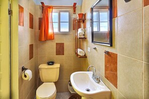 Un baño con inodoro, lavamanos y cortina de ducha.