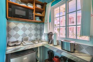 A kitchen with a microwave, toaster, and sink. - Central Caye Caulker Apartment w/ AC, Wi-Fi & Kitchen | Unit 2 (Caye Caulker)