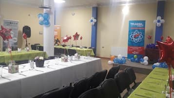 A conference room with tables set for a meeting, balloons, and banners.