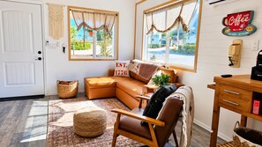 A cozy living room with a leather sofa, a wooden rocking chair, and a coffee machine on a wooden table. - 5 Mins from Lake/AC/Kids+Pets/Fenced Yard/Toys (Lake Isabella)