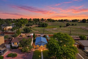 A residential area with houses, a clear sky, and a sunset. - Westside Bungalow | King Bed + Fenced Yard + Pets! (Colorado Springs)