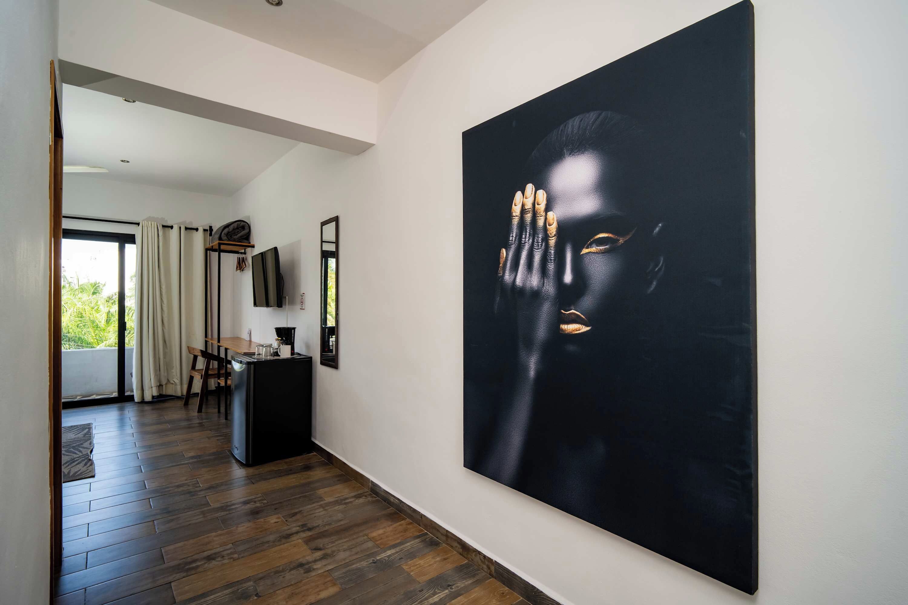 A modern interior with a large abstract painting, a dining area, and a kitchen.