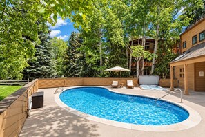A swimming pool with a wooden deck, lounge chairs, and a hot tub. - Downtown Aspen | Pool & Hot Tub | Walk to Gondola by Aspen Vacation Rentals™ (Aspen)