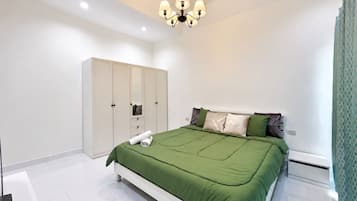 A bedroom with a bed, a wardrobe, and a ceiling light fixture.