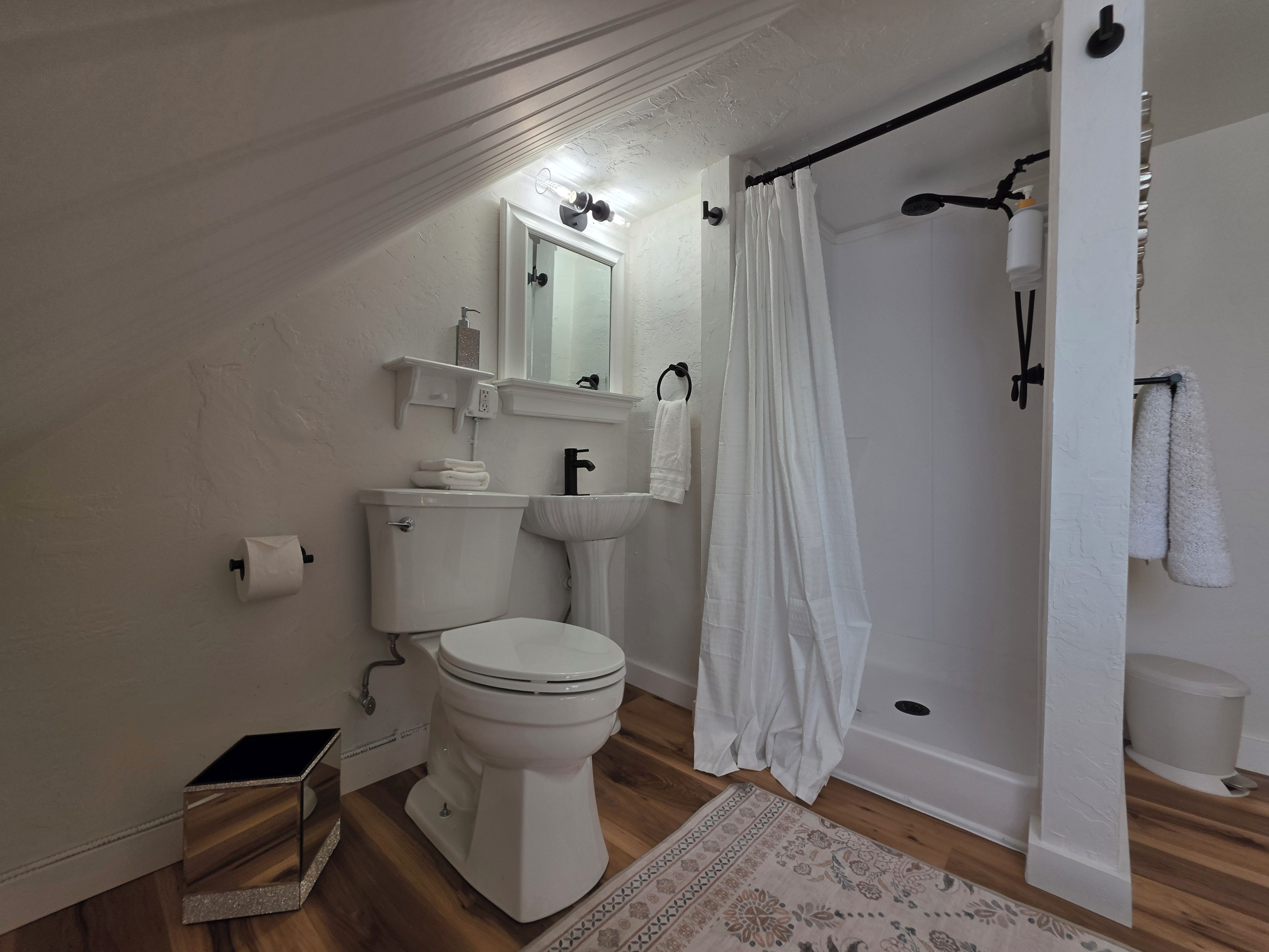 A modern bathroom with a toilet, sink, and shower area.