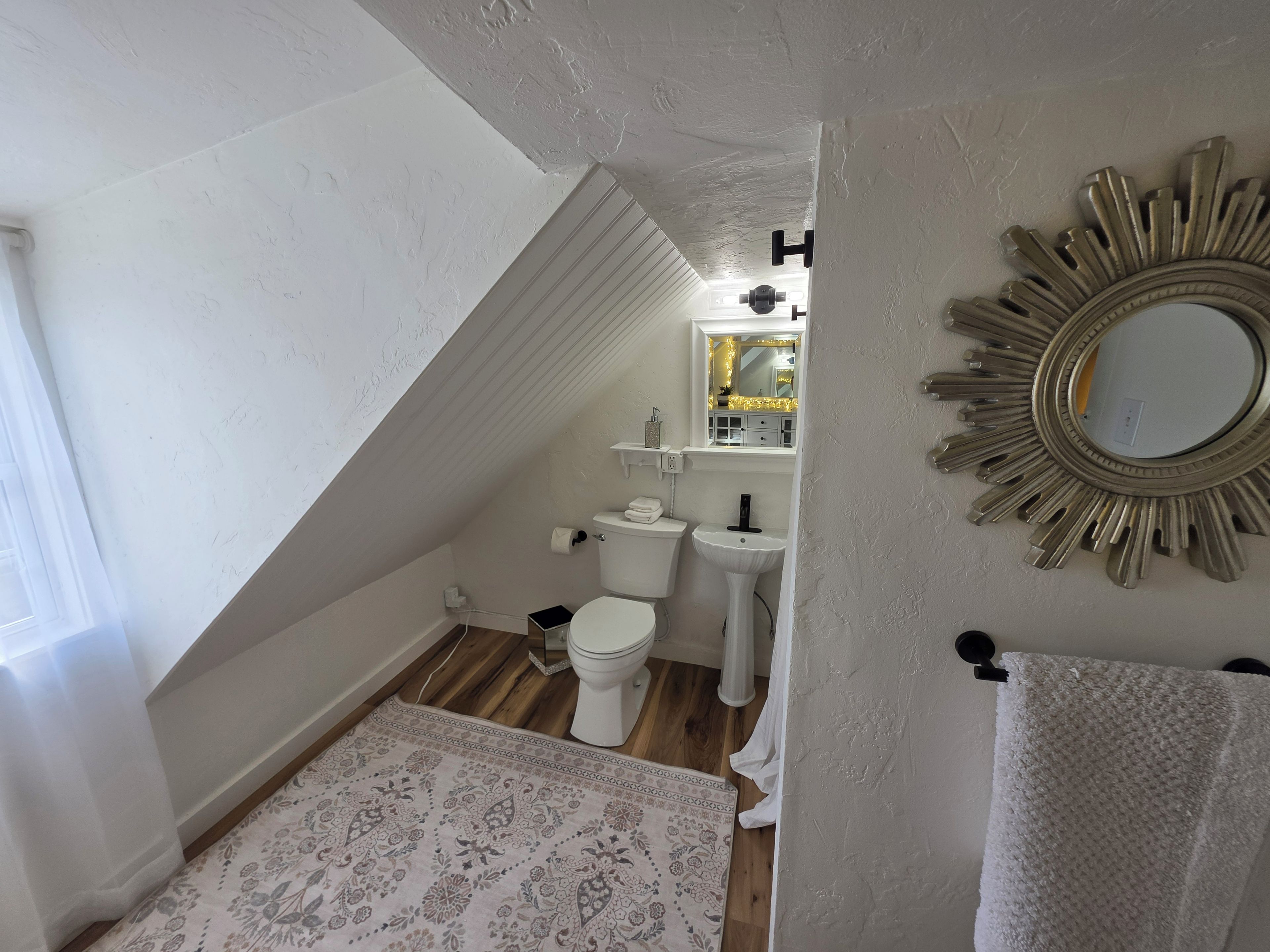 Een badkamer met toilet, wastafel en spiegel.