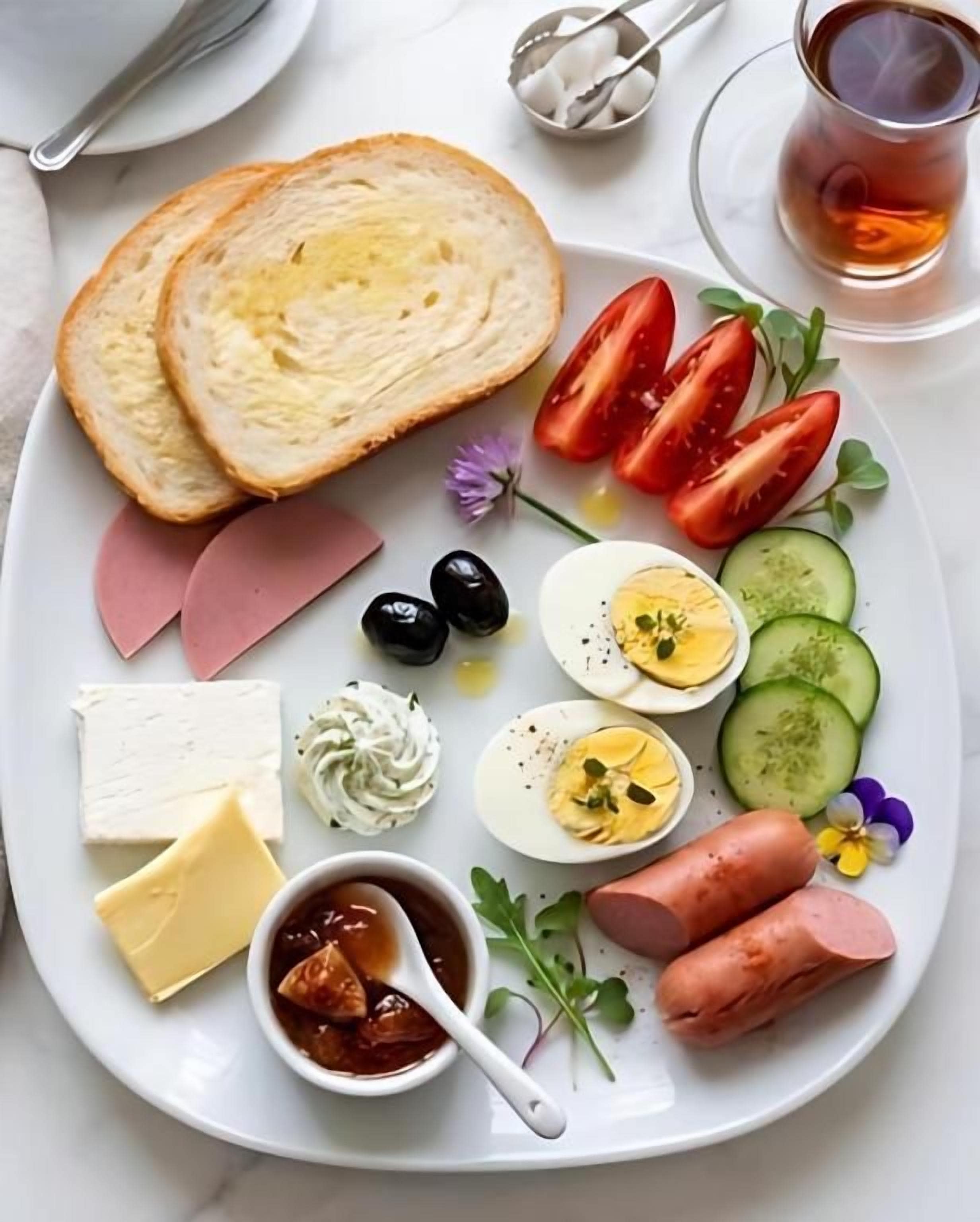 A plate with various food items including bread, tomatoes, cheese, eggs, and meat.
