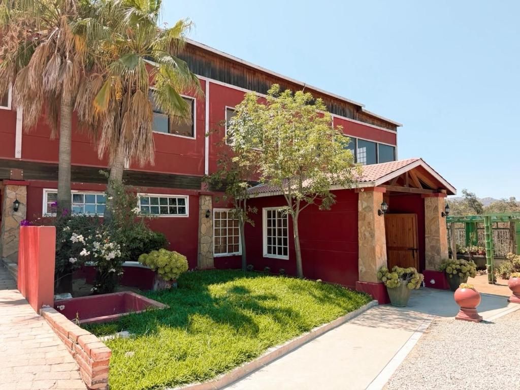 A red building with a brick pathway, a small tree, and a well-maintained lawn.