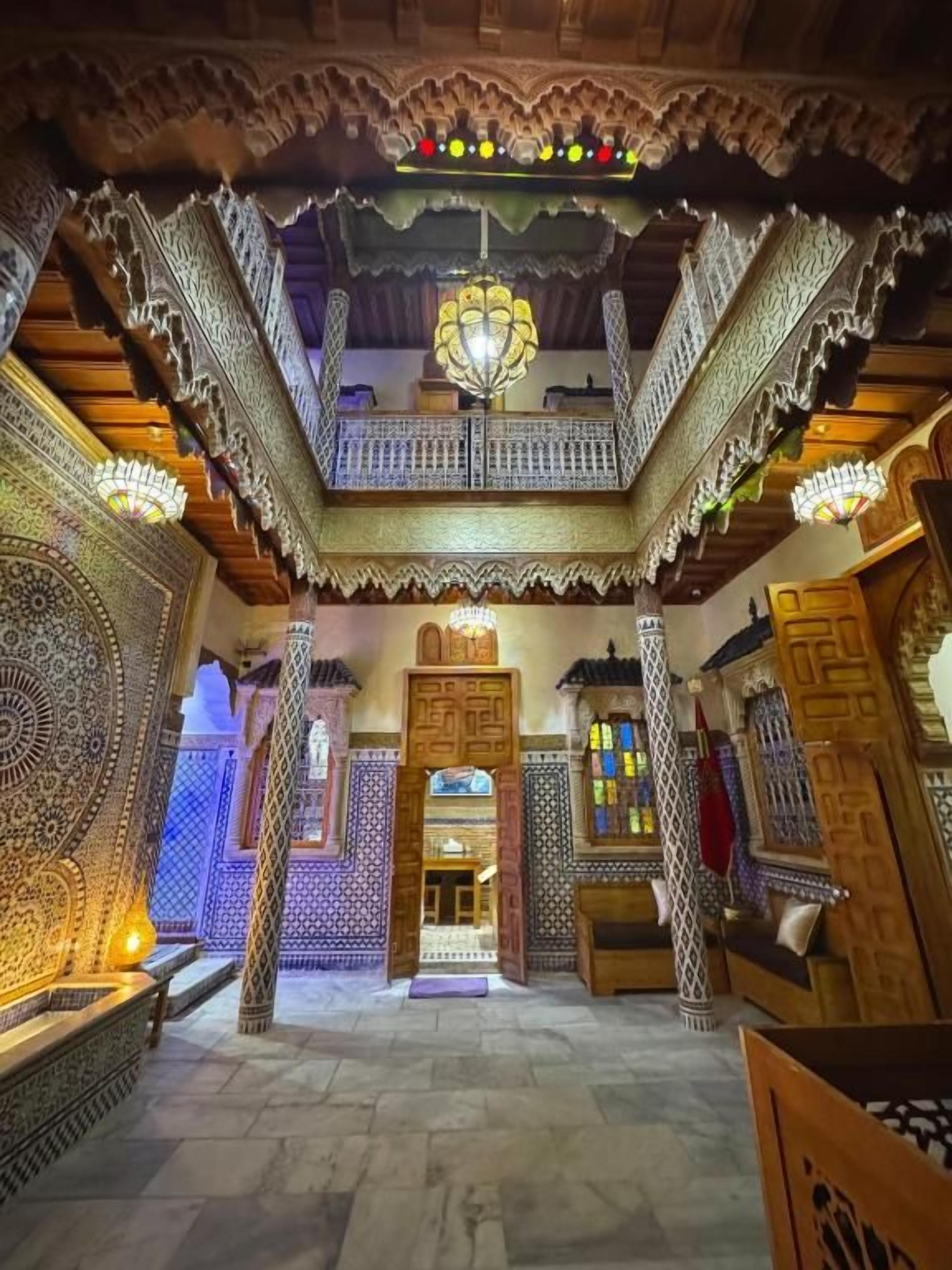An ornate interior with intricate patterns, a balcony, and a chandelier.
