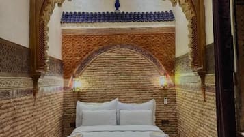 Ein Zimmer mit einem Bett, einem Zierbogen und Wandverzierungen.