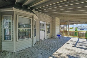 A covered porch with a wooden deck, a door, and a small table with a chair. - 4-Bedroom House with Private Office in Canal Winchester (Canal Winchester)