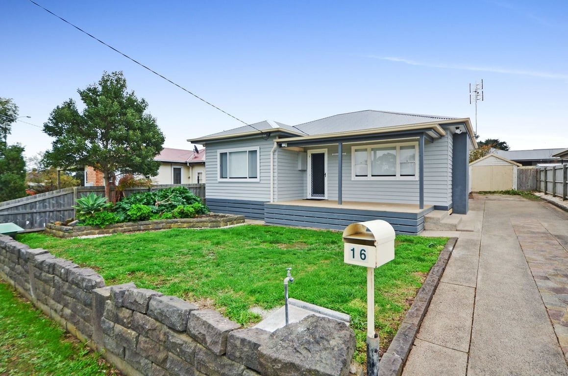 A single-story house with a front porch, a mailbox, and a well-maintained lawn.