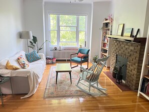 A living room with a sofa, a rocking chair, a fireplace, and a bookshelf. - Bright 3-bedroom apartment in Montreal (Outremont) (Montréal)