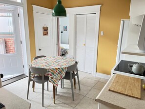A compact kitchen with a dining table, chairs, a green pendant light, and a white refrigerator. - Bright 3-bedroom apartment in Montreal (Outremont) (Montréal)