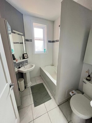 A bathroom with a sink, toilet, bathtub, and a window. - Bright 3-bedroom apartment in Montreal (Outremont) (Montréal)