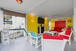 Quarto claro e ensolarado com mobiliário branco, uma parede amarela e uma porta vermelha.