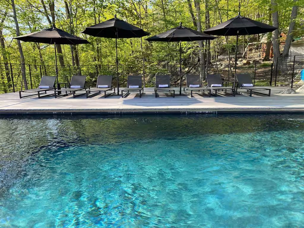 Un espace aménagé au bord de la piscine, avec des chaises longues et des parasols.