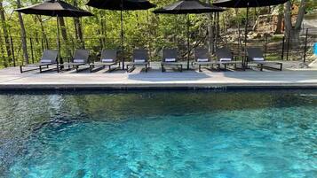 Un espace aménagé au bord de la piscine, avec des chaises longues et des parasols.