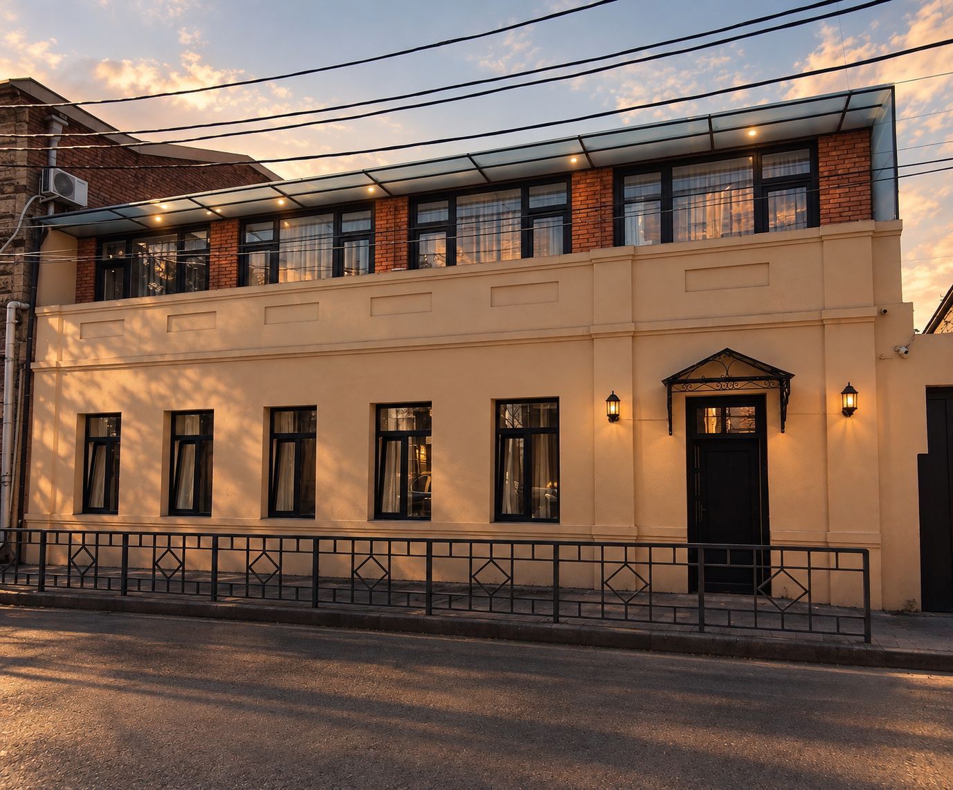A two-story building with a balcony, multiple windows, and a gated entrance.