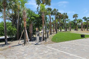 A paved walkway with palm trees and a grassy area. - Enjoy stunning Gulf views from this beachfront Sanibel condo - Lighthouse Point 223 (Sanibel Island)